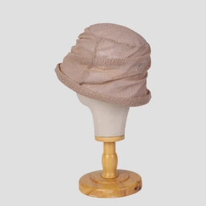 Macro view of light brown lace mesh bucket hat with pleated texture on a model stand