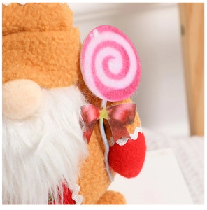 Close-up of ginger gingerbread gnome plush with pink lollipop and soft faux fur texture