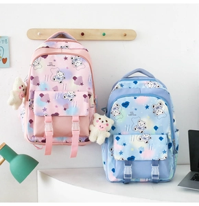 Detail of macaron-colored school backpacks with cute cartoon prints and plush bear charms