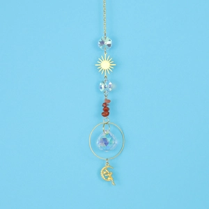Macro shot of sun catcher with faceted crystal balls and red agate stones on gold chain