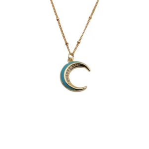 Dettaglio del ciondolo a mezza luna dorata con smalto blu e pietre di zirconia scintillanti