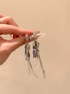 Gros plan de boucles d'oreilles argentées à pampilles en épi avec zircons étincelants