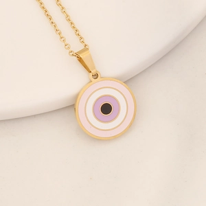 Macro shot of gold necklace featuring a colorful pink and purple evil eye pendant charm