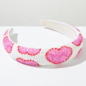 Close-up of handmade white beaded headband featuring pink and red heart patterns