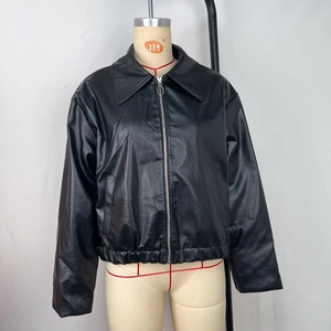 Détail de la veste en similicuir noir mat avec de larges revers et fermeture éclair