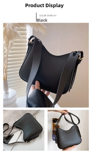 Detail view of a black vintage square bag with matte leather texture and gold hardware