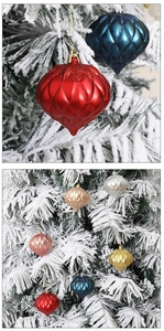 Detailed view of colorful glitter onion-shaped Christmas ornaments on a snowy tree