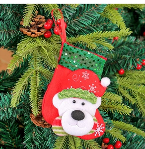 Detail eines roten Weihnachtsstrumpfs mit grünen Pailletten und Eisbär-Motiv