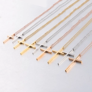 Detailed close-up of polished stainless steel cross pendants in gold, silver, and rose gold