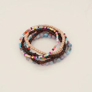 Detail of multi-layer bohemian seed bead bracelet set with wood and resin textures