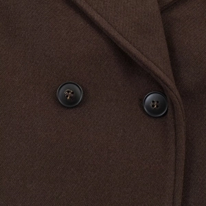 Detailed close-up of dark brown wool coat fabric with double black buttons