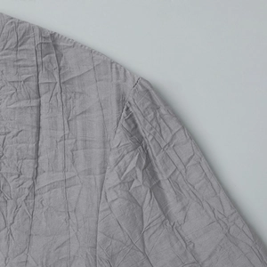 Détail du tissu gris à texture froissée et des coutures sur l'épaule et la manche