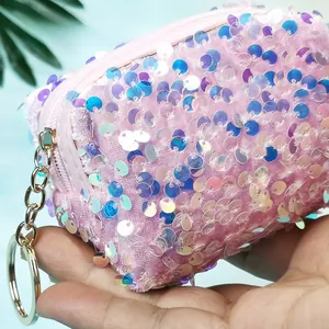 Macro-opname van een roze mini-portemonnee met pailletten en gouden sleutelhangerring