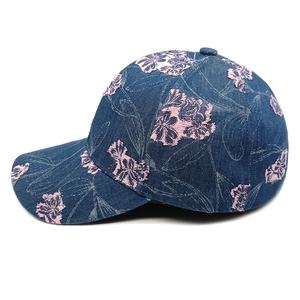 Detail of floral embroidery on navy denim baseball cap with vintage frayed edges