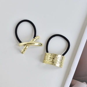 Detailed macro view of gold alloy U-shaped ponytail holders with sleek metallic finish