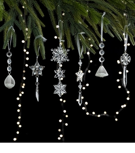 Macro detail of six acrylic Christmas tree ornaments with snowflakes and crystal teardrops