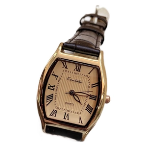 Tonneau shaped gold ladies watch with dark brown leather strap and roman numerals