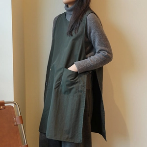 Deep green cotton-linen apron with large pockets and side slit design shown on model