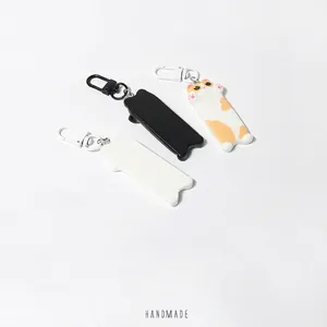 Three cute cartoon cat keychains in black, white and calico patterns with matching hooks