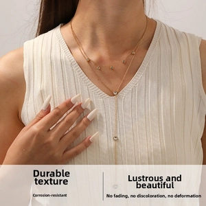 Double-layered gold stainless steel necklace featuring zircon charms and heart pendant detail
