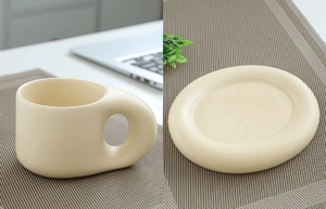 Detail view of a cream ceramic chunky mug with a thick handle and matching round coaster
