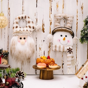 Christmas Santa and Snowman plush door hangers on rustic wooden wall with festive decor