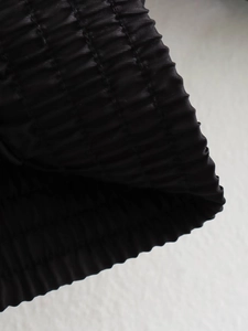 Macro detail of black bomber jacket featuring elasticated pleated cuffs and fabric texture