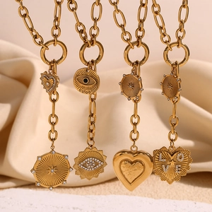 Detail of 18K gold plated necklaces featuring heart, evil eye, and starburst pendants