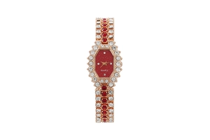 Detail of a square gold watch with red crystals and red octagon dial on white background
