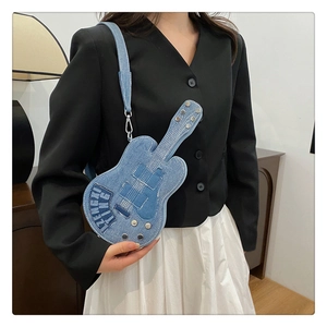 Detail of unique guitar-shaped blue denim crossbody bag with silver rivet studs