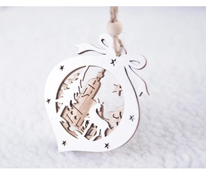 Close-up of laser-cut wooden Christmas ornament with reindeer silhouette and bow detail