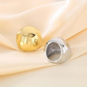 Close-up of polished gold and silver domed rings on smooth champagne satin fabric
