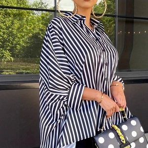 Detailed side view of black and white vertical striped shirt with asymmetrical hem