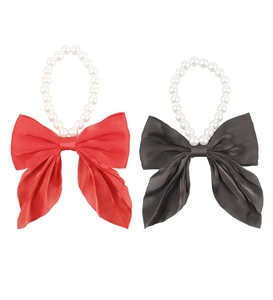 Detail of red and black satin bow pet collars with white pearls on a clean white background