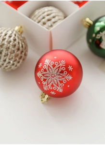 Detail of red matte Christmas ball with silver snowflake glitter and golden hanger hook
