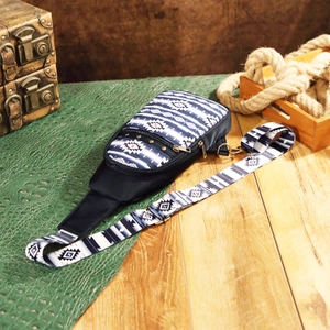 Detail of bohemian Aztec sling bag featuring tribal print strap and bronze hardware