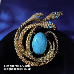 Detailed close-up of vintage golden snake brooch with blue gemstone and scale texture
