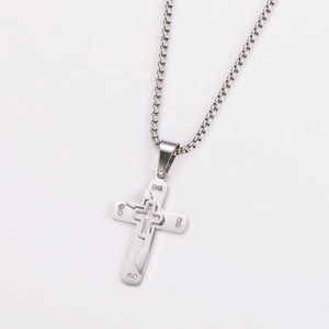 Macro view of silver stainless steel double layer cross pendant with inlaid crystals