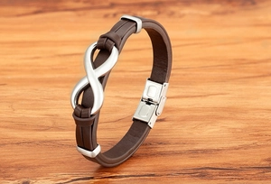 Close-up of brown leather bracelet with silver infinity symbol and stainless steel clasp