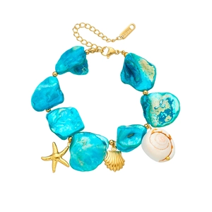 Detail of bohemian gold bracelet featuring blue irregular stones and sea shell charms
