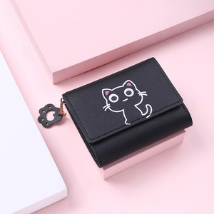 Detail of short black wallet with cute white cat print and paw-shaped charm detail