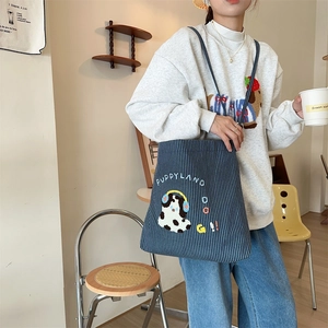 Detailed towel embroidery puppy patch on a blue striped canvas shoulder bag