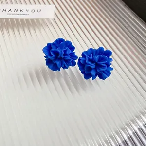 Deep blue resin flower stud earrings with a matte textured finish on ribbed glass
