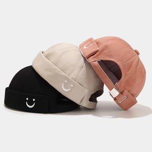 Docker hats in black, beige and brick red with smiley face embroidery and adjustable straps