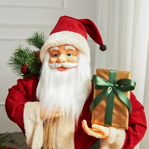 Classic Santa Claus decoration with red suit, holding a golden gift box and pine branch