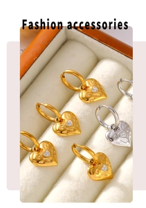 Macro view of gold and silver hammered heart earrings with micro-inlaid crystals
