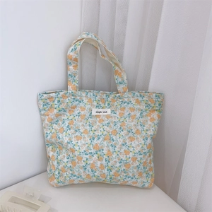Detail of floral canvas tote bag with orange and green patterns and simple wish label
