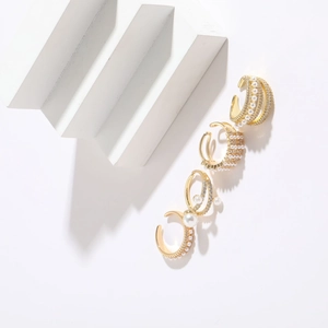 Elegant 14K gold plated C-shaped hoop earrings set with pearls and zircons on white steps