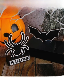 Detail view of wooden Halloween spider and bat tabletop signs on black display stand