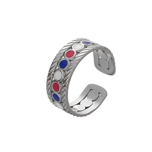 Detailed macro of stainless steel ring with colorful enamel inlay and braided texture